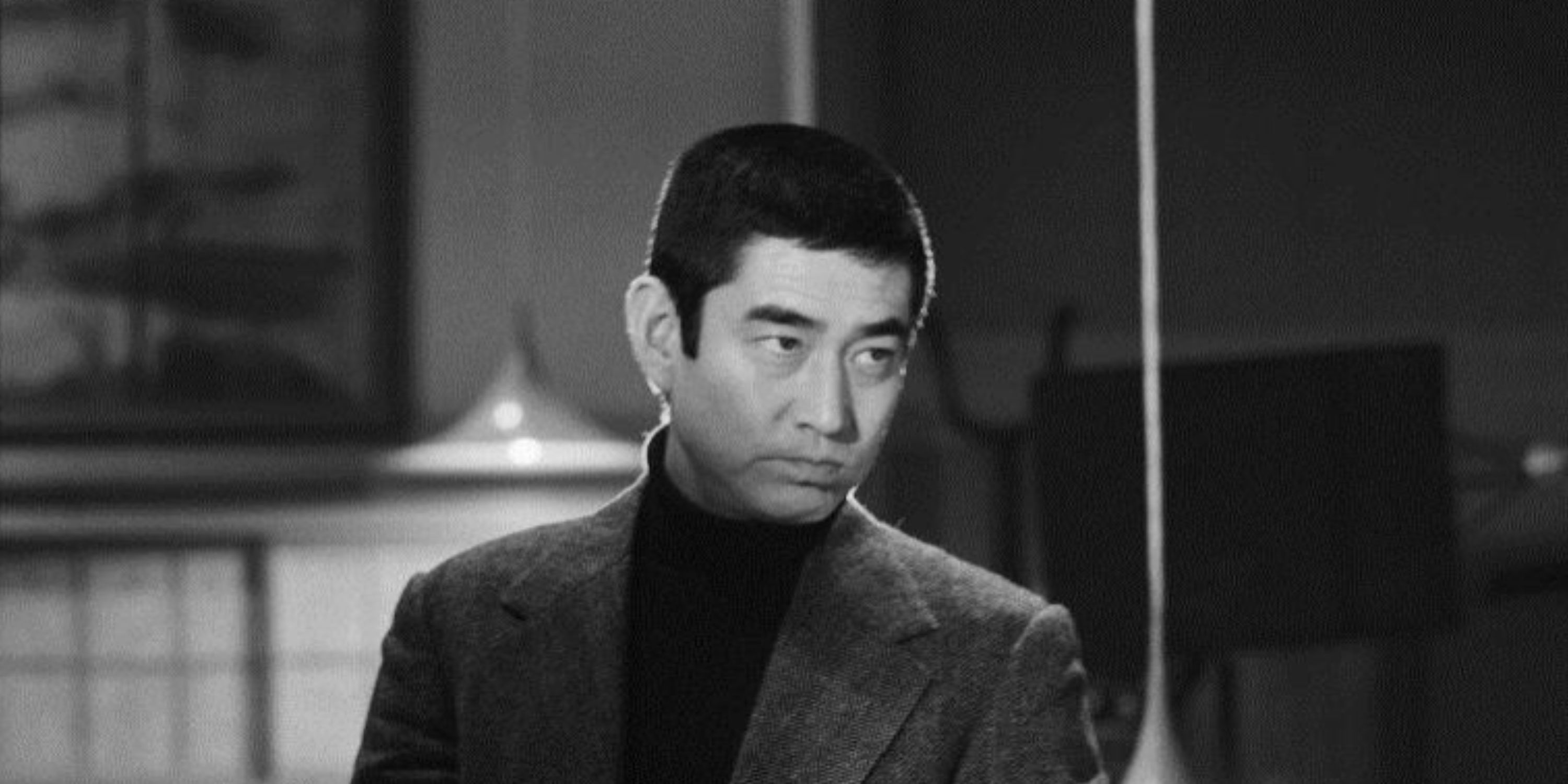 Ken Takakura, a prominent 20th-century Japanese actor, looks stoically at something off camera.