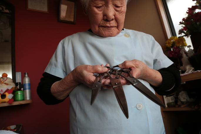 Shitsui Hakoishi holding three scissors